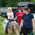 Enjoying a pony ride before the show.  Pictured: Olivia Beck (great-granddaughter of founders William and Alice Beck), alongside her mother Mindy Mertz-Beck.